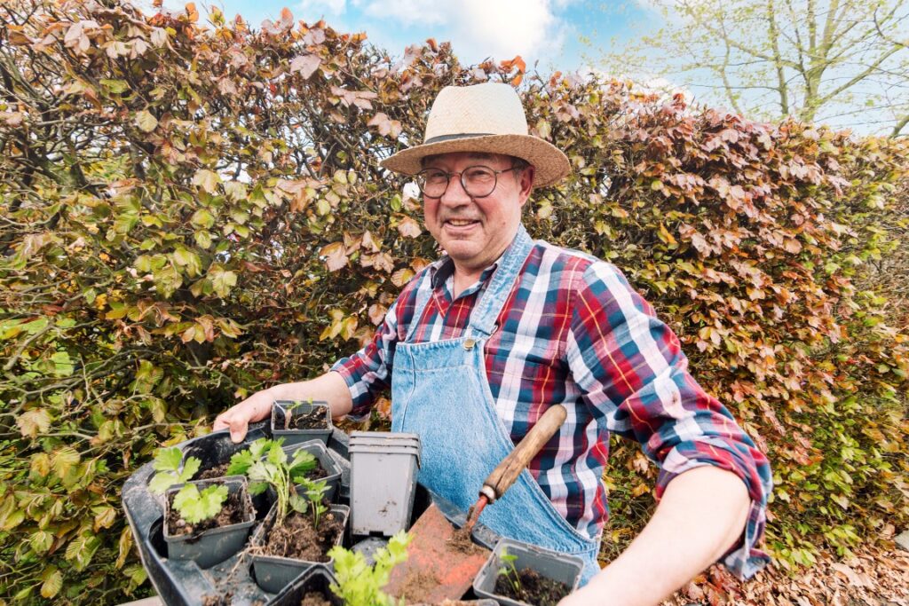 Ervaren tuinspecialist van Mr. Leaf die verse planten selecteert voor een borderpakket op maat.