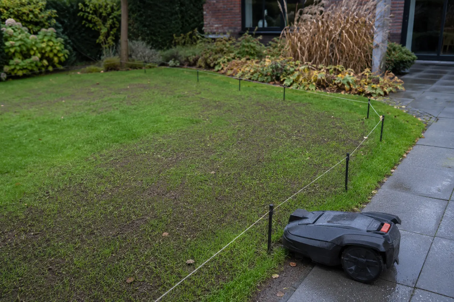Robotmaaier geparkeerd naast een pas doorgezaaid gazon